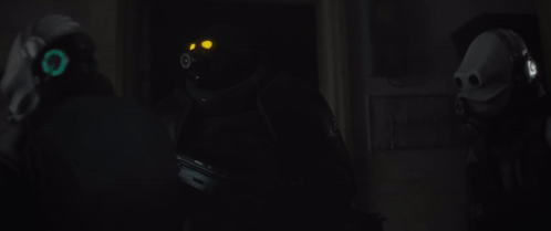 Man in Gas Mask Holding Gun in Dark Room