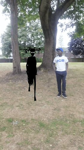 Man in GB Shirt Standing in Front of Tree