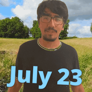 Man in Glasses and Black Shirt in Field on July 23
