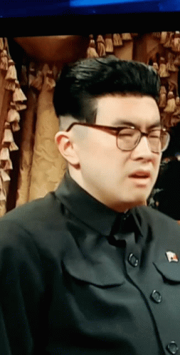 Man in Glasses and Black Shirt with Pin