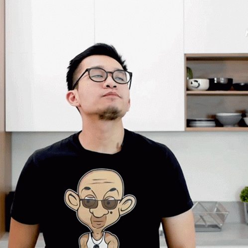 Man In Glasses And Black T-Shirt With Cartoon Man GIF