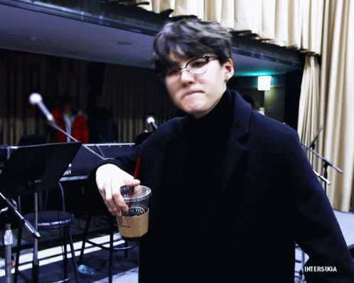 Man in Glasses and Black Turtleneck Holding Coffee With Straw