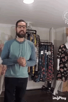 Man in Glasses and Blue Shirt at Clothes Display