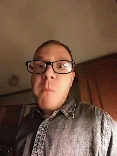 Man In Glasses And Denim Shirt Making A Face GIF