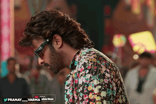 Man in Glasses and Floral Shirt Listening to Pranay Varma on YouTube Music