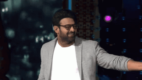 Man In Glasses And Gray Jacket In Front Of Purple Light GIF