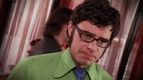 Man in Glasses and Green Shirt Making Sad Face