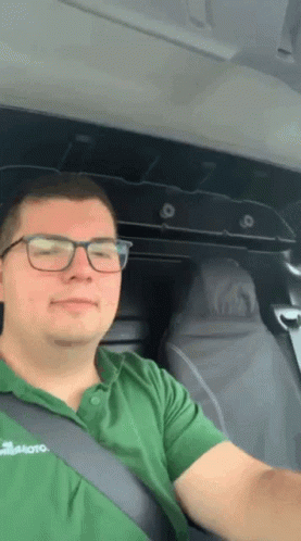 Man In Glasses And Green Shirt Sitting In Vehicle GIF