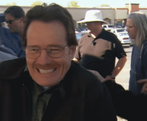 Man in Glasses and Hat Smiling at Group