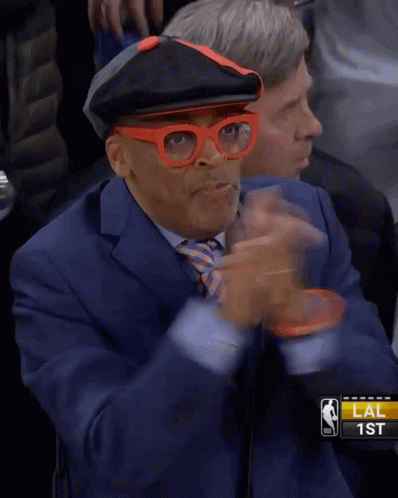 Man in Glasses and Hat Thumbs Up at Basketball Game