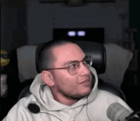 Man In Glasses And Hoodie Sitting At Microphone GIF