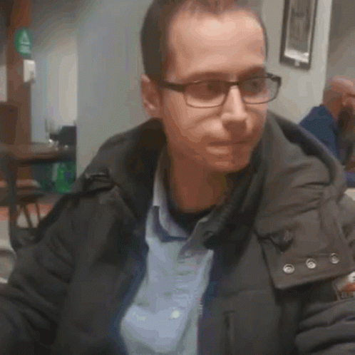 Man in Glasses and Jacket Sitting in Restaurant