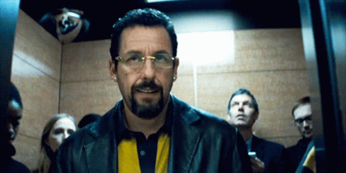 Man in Glasses and Leather Jacket Smiling in Elevator