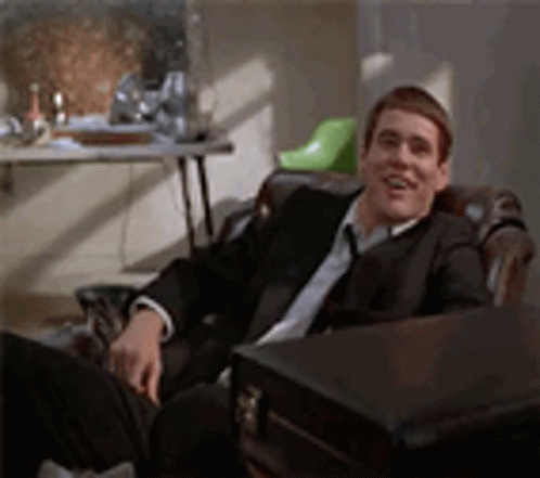 Man In Glasses And Name Tag In Front Of White Building GIF