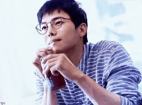 Man in Glasses and Striped Shirt Smoking Cigarette Holding Coffee