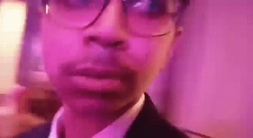 Man in Glasses and Suit at Pink Wall