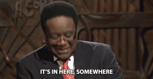 Man in Glasses and Suit Says It's In Here Somewhere