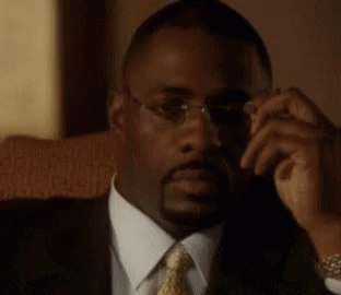 Man in Glasses and Suit Sitting in Chair