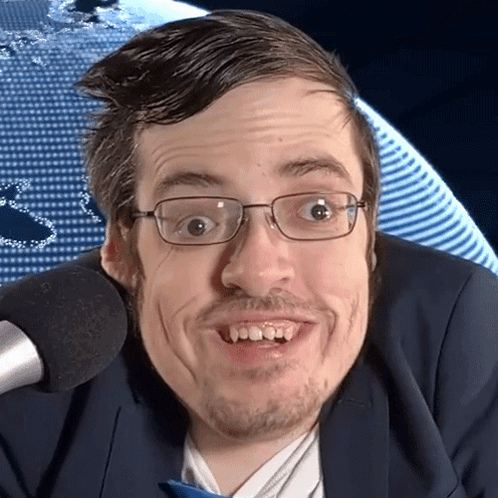 Man In Glasses And Suit Smiling At Microphone GIF
