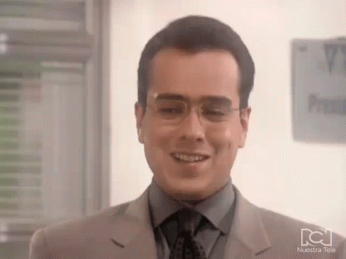 Man In Glasses And Suit Smiling By Nuestra Tele Sign GIF