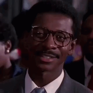 Man In Glasses And Suit Smiling In Crowd GIF