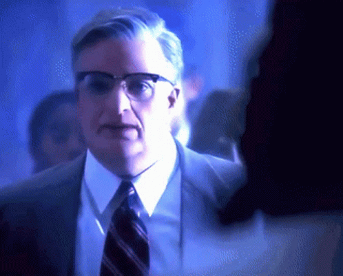 Man in Glasses and Suit Standing in Crowd