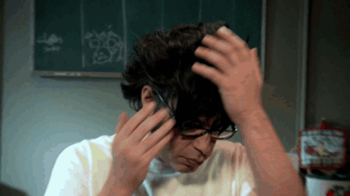 Man in Glasses and White Shirt Holding Hair