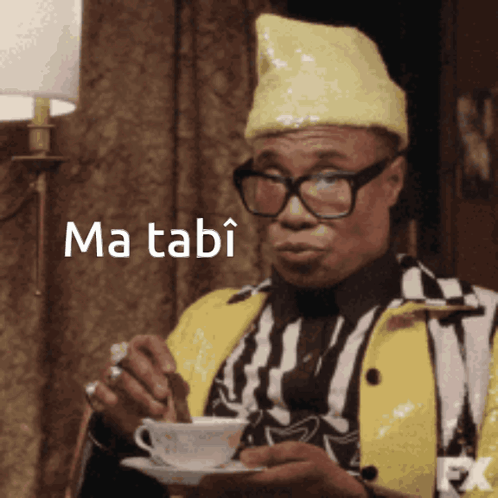 Man in Glasses and Yellow Hat Holding Coffee Ma Tabi