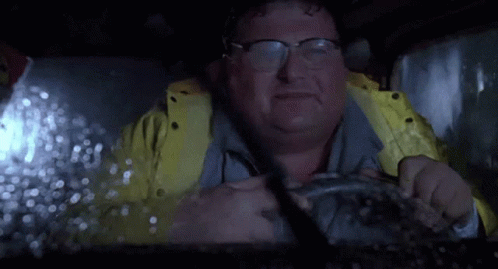 Man in Glasses and Yellow Jacket Driving in Rain