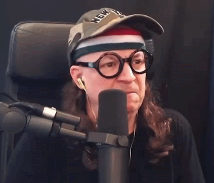 Man In Glasses And York Hat Says Boo Into Microphone GIF