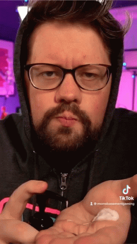 Man In Glasses Putting Lotion On Hand GIF
