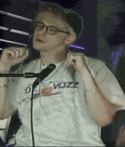 Man in Glasses Singing Into Microphone