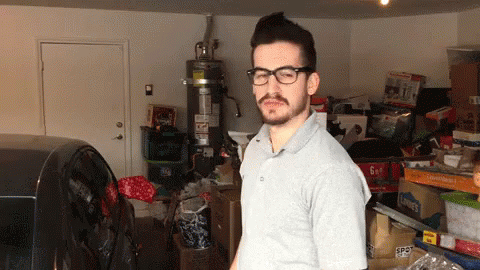 Man In Glasses With 6 Gallon Box In Garage GIF