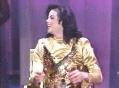 Man in Gold Dress Holding Trophy on Stage