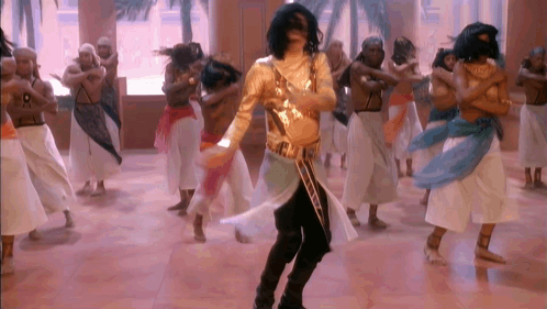 Man in Gold Outfit Dancing with Dancers