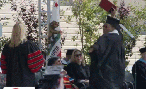 Man in Graduation Cap and Gown Holding Diploma