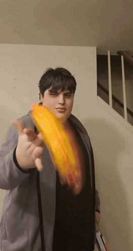 Man in Gray Jacket Holding Yellow Object