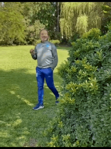 Man in Gray Sweatshirt and Blue Pants Standing in Park