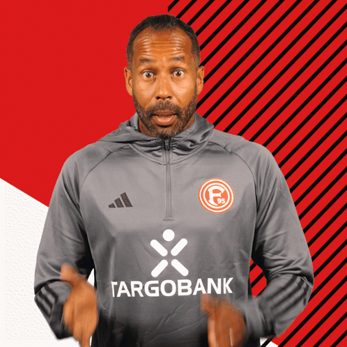 Man In Gray Targobank Shirt Holding Hands Up GIF