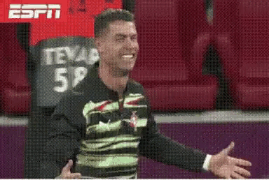 Man in Green and Black Shirt Smiling in Stadium