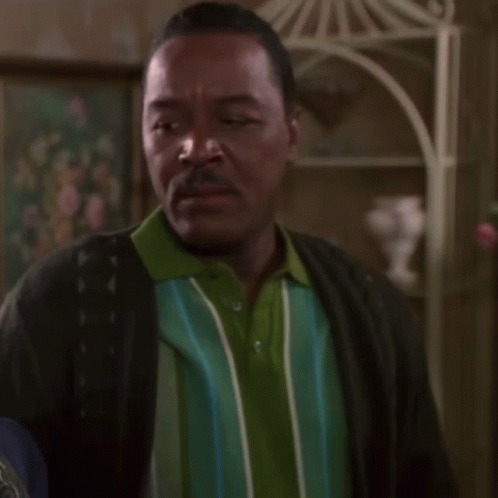 Man in Green and Blue Striped Shirt and Black Cardigan