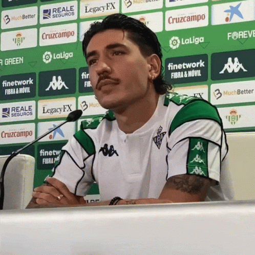 Man in Green and White Shirt in Front of LaLiga Logo Wall