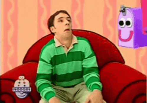 Man In Green And White Striped Shirt Sitting In Red Chair GIF