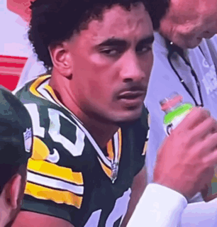 Man In Green And Yellow Football Uniform Holding Gatorade Bottle GIF