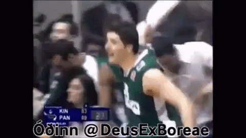 Man in Green Basketball Jersey Standing in Front of Crowd