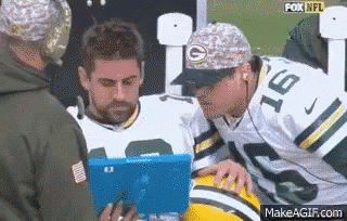 Man in Green Bay Packers Jersey Looking at Tablet