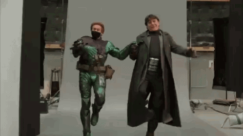 Man in Green Costume and Man in Black Coat Dancing