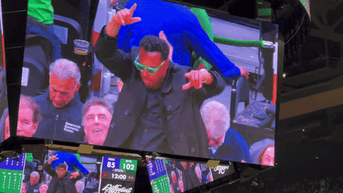 Man in Green Glasses Dancing in Front of Scoreboard 85 102