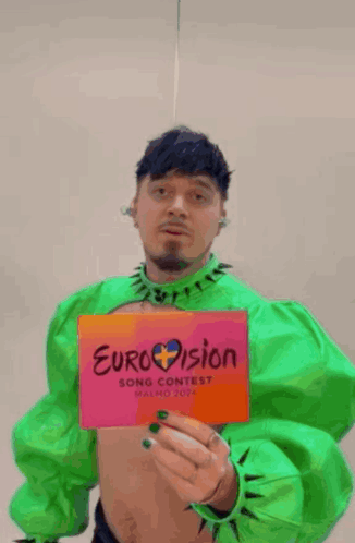 Man in Green Holding Eurovision Sign