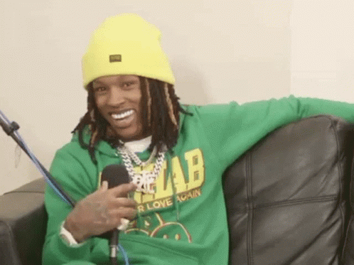 Man in Green Hoodie and Yellow Hat on Couch